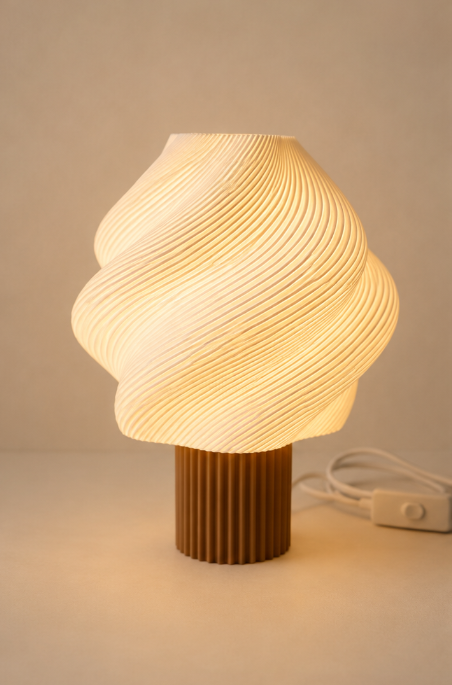 Candeeiro Aura Lamp aceso, difundindo luz quente através das linhas onduladas